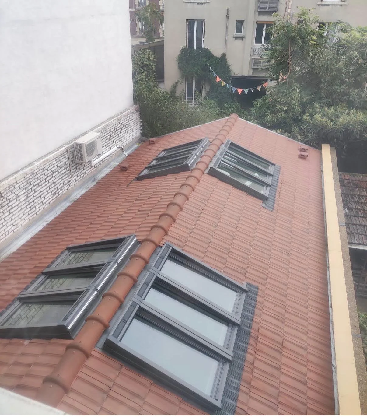 Toiture en tuiles avec plusieurs fenêtres de toit.
