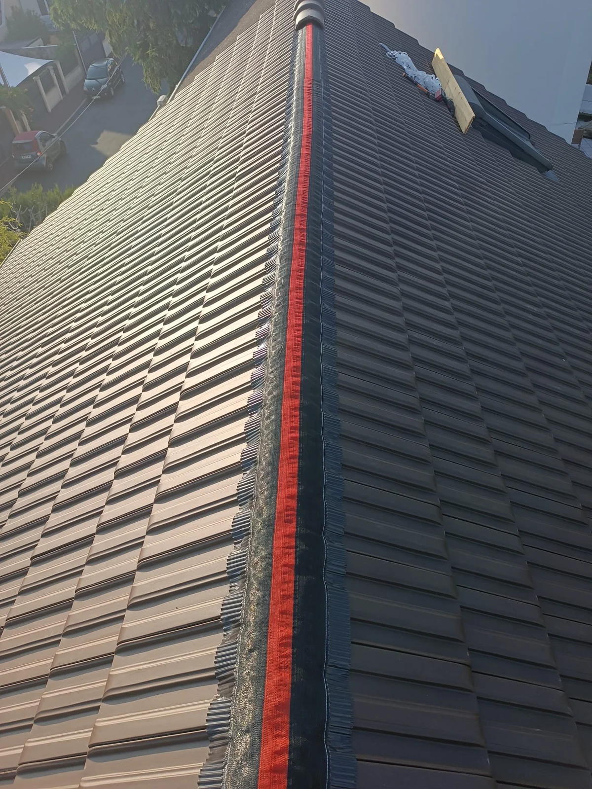 Détail de l’étanchéité du faîtage sur une toiture sombre.