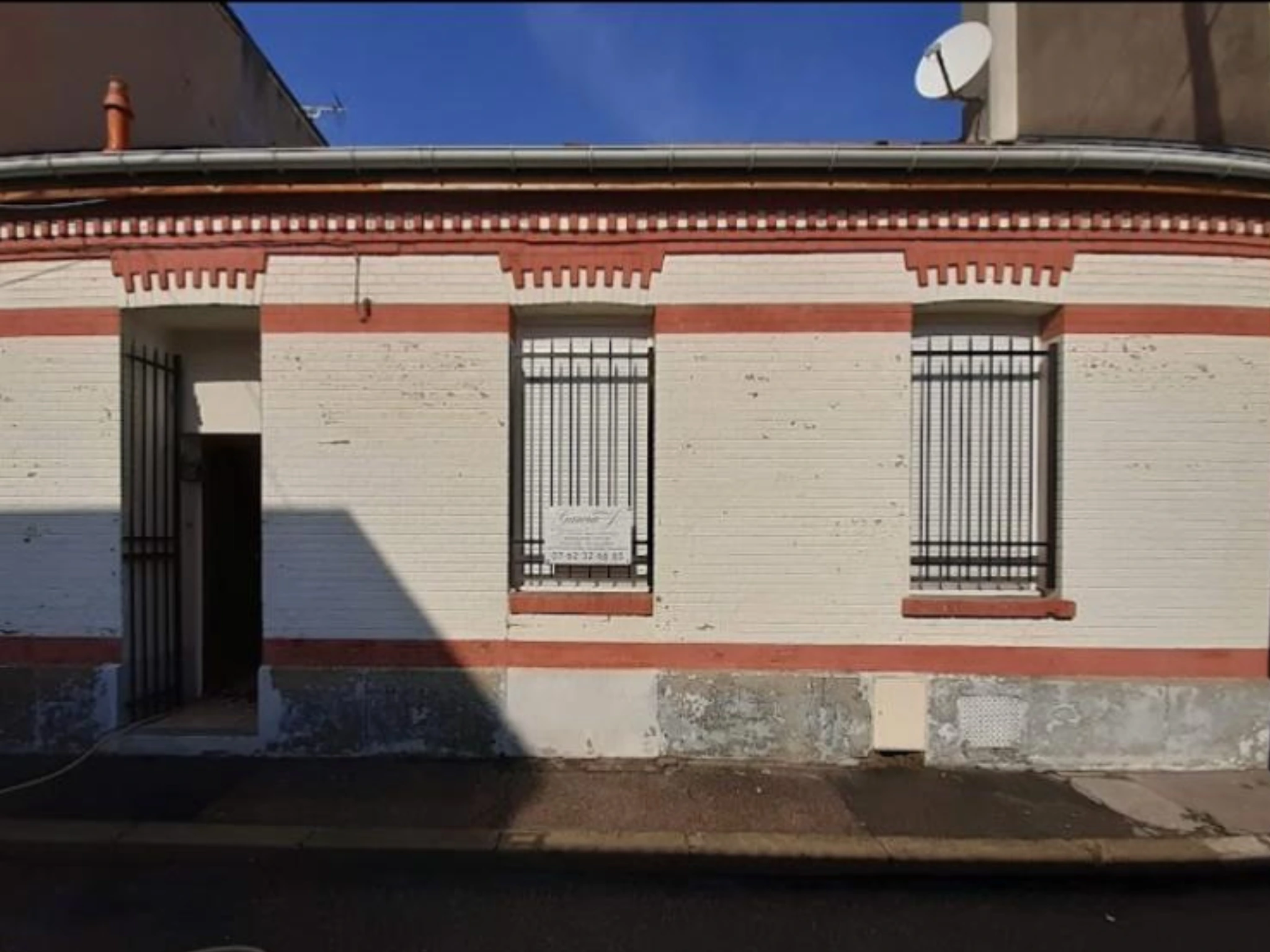 Façade de maison avant le ravalement : enduit sali, teinte inégale et encadrements grisés